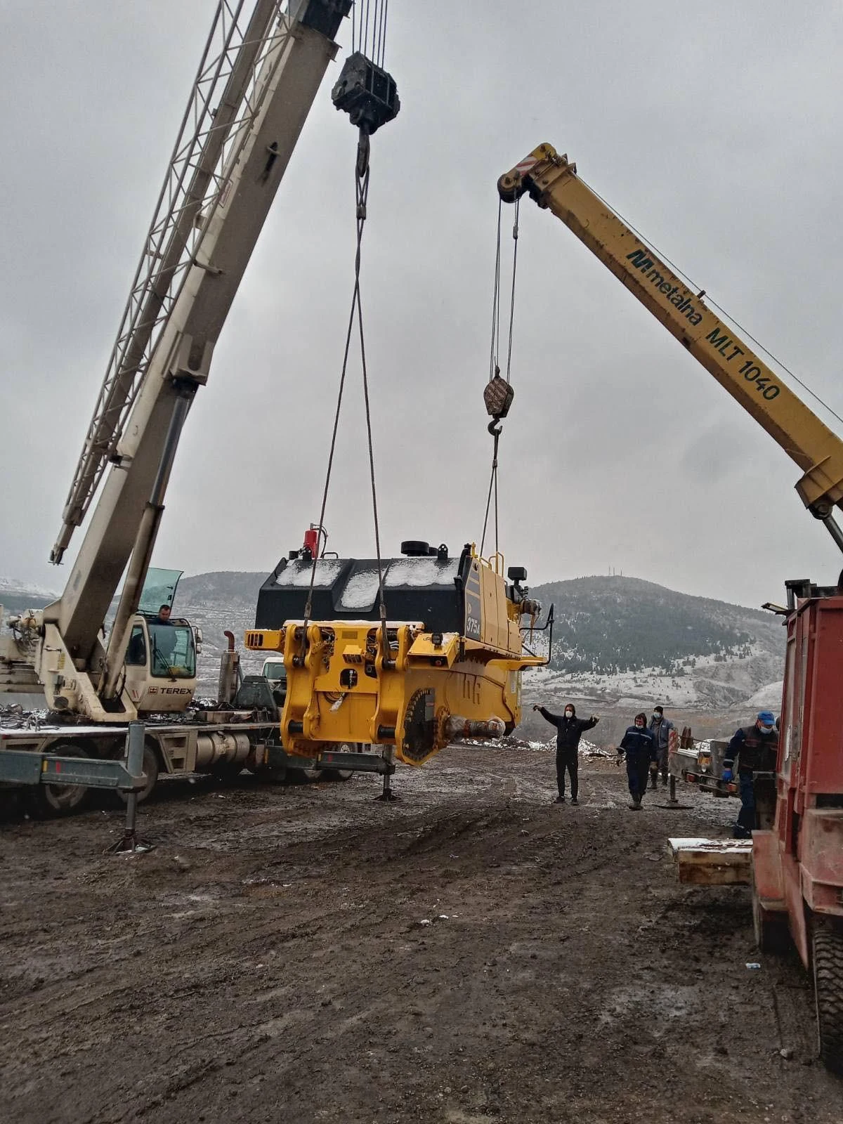 Special transport of heavy machinery during crane loading.